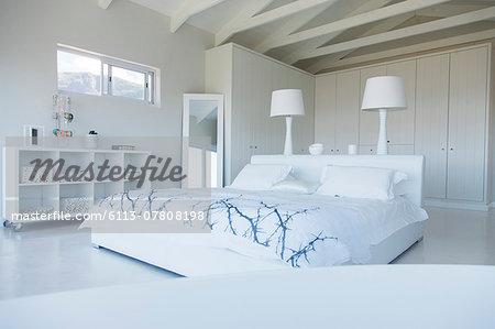 Modern white bedroom interior with double bed