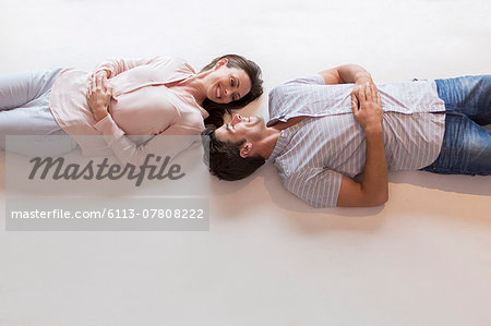 Couple looking at each other while lying on table