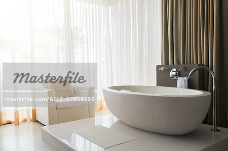 View of modern and luxurious bathroom with bathtub and armchair