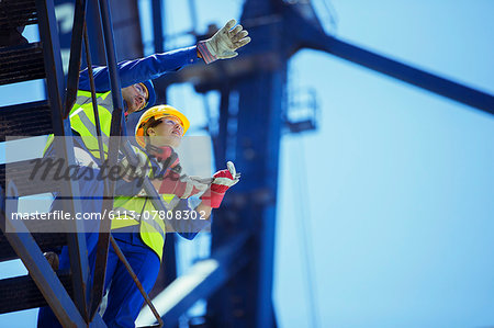 Low angle view of workers talking on crane