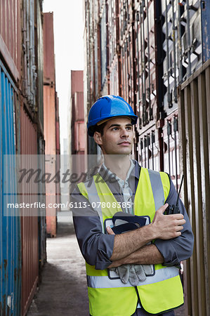 Worker standing between cargo containers