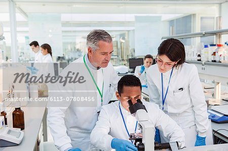 Scientists using microscope in laboratory Scientists using microscope in laboratory