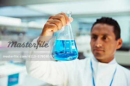 Scientist examining sample in beaker in laboratory