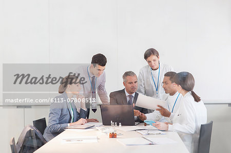 Scientists and business people talking in conference room