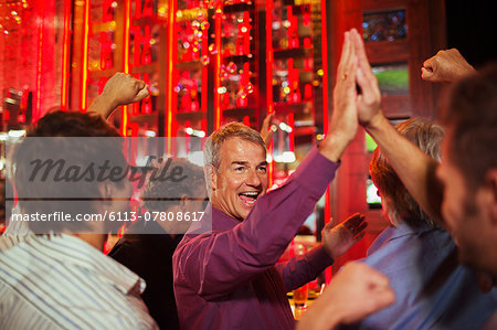 Men high fiving each other in nightclub