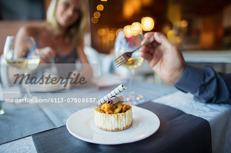 Couple eating dessert in fancy restaurant