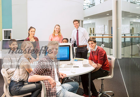 Group portrait of teenage students with their teacher at table