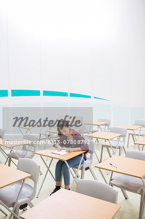 Female student sitting alone in classroom during GCSE exam