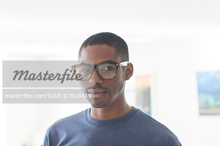 Portrait of young businessman wearing glasses standing in office