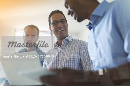 Men using digital tablet and laptop in office