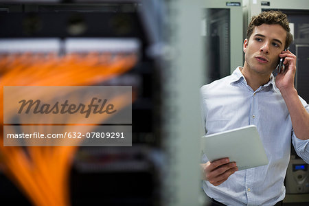 Computer technician performing maintenance check of mainframe equipment