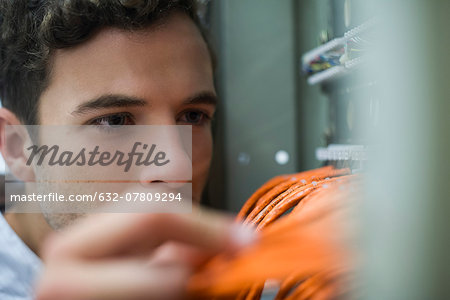 Computer technician performing maintenance work on networking equipment