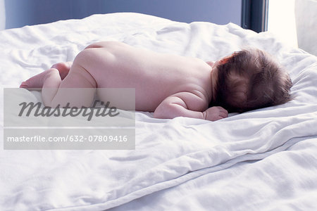 Baby lying on stomach on bed