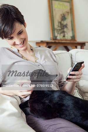 Woman sitting on sofa with cat on her lap