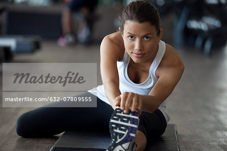 Woman at gym warming up with leg stretches