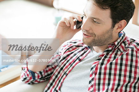 Man talking on cell phone at home