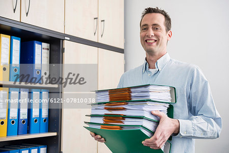 Portrait man carrying pile filing folders Portrait man carrying pile filing folders