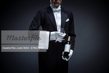 Man in a tuxedo with bottle and glass