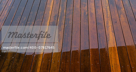 Timber floorboards on outside deck wet from rain water for background