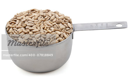 Hulled sunflower seeds in an American cup measure, isolated on a white background