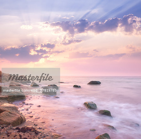 Dawn sunrise landscape over beautiful rocky coastline in the Sea with sunbeams