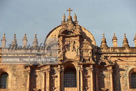 Ornate red granite facade of the historic Cathedral in the Plaza de Armas of Cusco, Peru. Construction of the Cathedral dates back to 1560 and sits on top of an old Inca Palace.