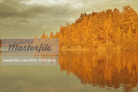 Autumn landscape. Lake evening view with island and rainy sky.