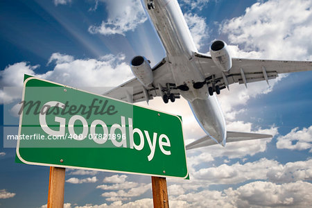 Goodbye Green Road Sign and Airplane Above with Dramatic Blue Sky and Clouds.