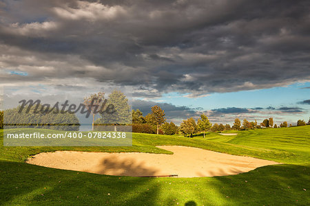 Summer golf course after storm at sunset