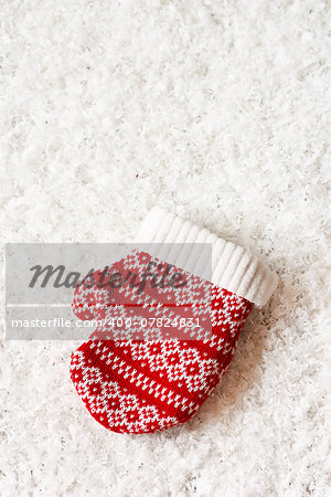 Christmas decoration with decorative knitted mitten on snow.