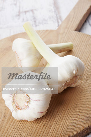 Garlic bulb on wooden kitchen board. Seasonal healthy vegetable eating.