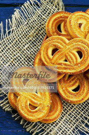 Arrangement of Homemade Shape Pretzel Sugar Cookies closeup on Sackcloth isolated on Dark Blue Wooden background. Top View