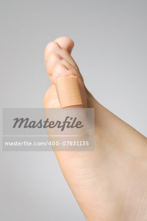 Injured female toe with adhesive bandage