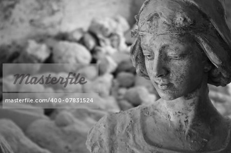A monochrome plaster statue in a sculptorâ??s studio in Volterra, Italy. The statue looks like meditating about her origin, the stone.