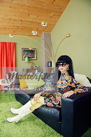 Calm groovy woman sitting on leather sofa