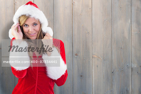 Festive blonde smiling at camera against pale grey wooden planks