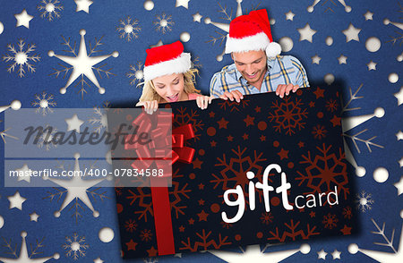 Young festive couple against gift card with festive bow