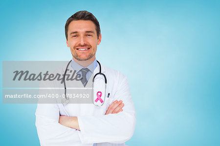 Handsome young doctor with arms crossed against blue vignette