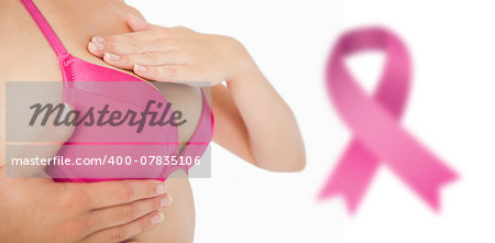 Closeup of woman performing self breast examination against breast cancer awareness ribbon