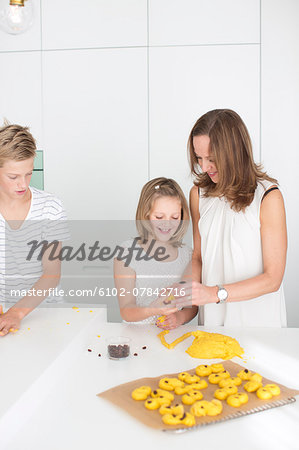 Mother and kids preparing saffron rolls