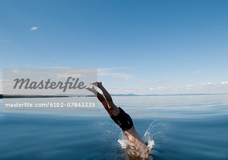 Mature man jumping in sea