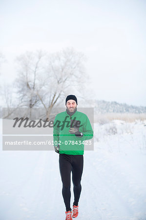 Mid adult man running at winter