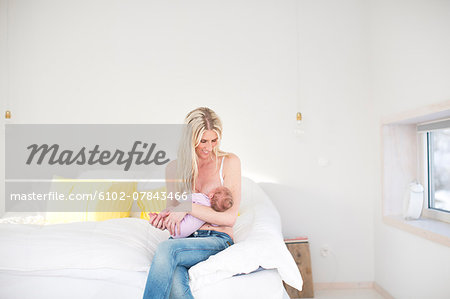 Woman breastfeeding newborn daughter