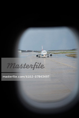 View of plane on runway through airplane window