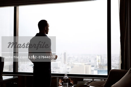 Man looking through window at cityscape