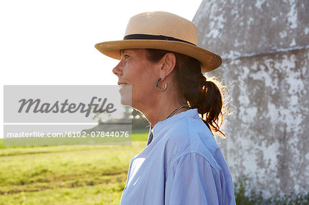 Mature woman wearing sun hat looking away