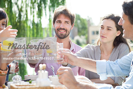 Family clinking glasses at outdoor gathering