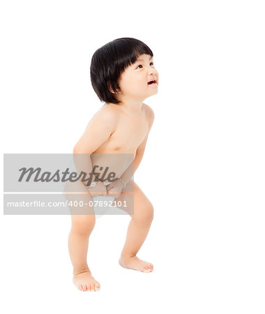 happy baby girl in a diaper standing and looks up isolated on white background