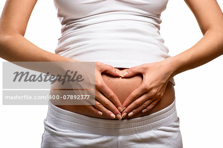 Woman holding her hands in a heart shape on her pregnant belly