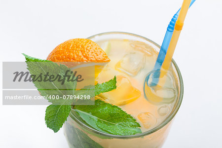 Glass of fresh made non-alcoholic drink citrus lemonade with ice cubes, mint , orange segment and straws. Top view on white background